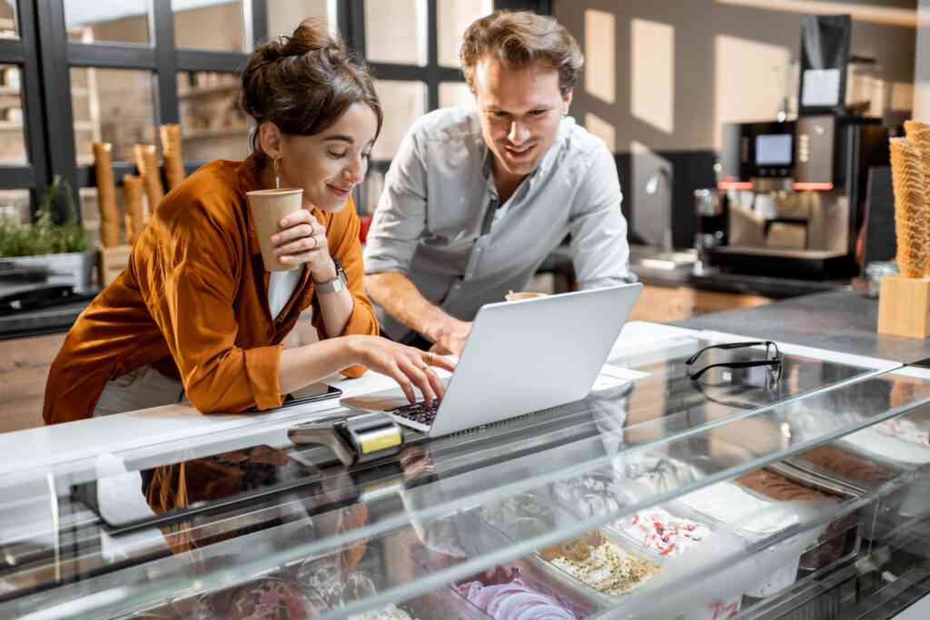 Man and woman use laptop to manage business