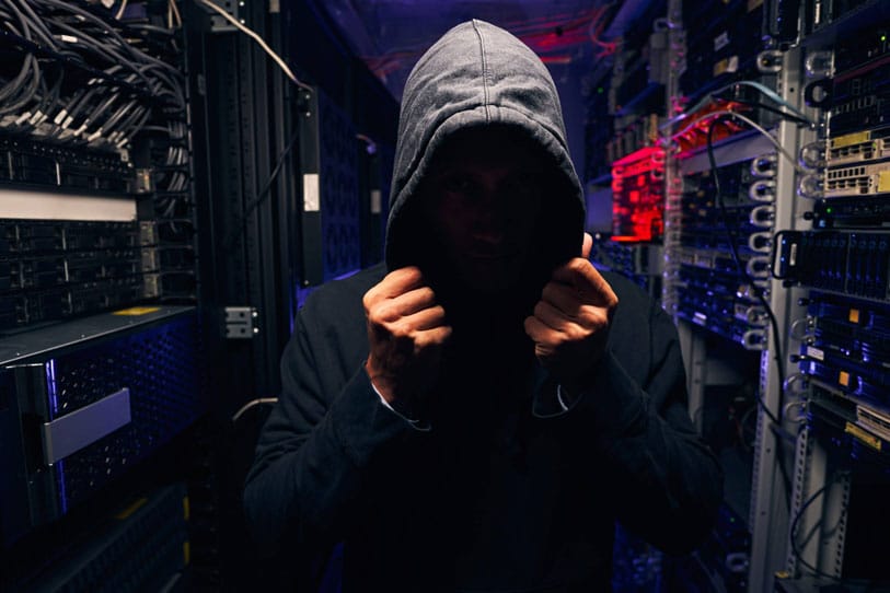 A hooded IT guy hiding in the data storage room